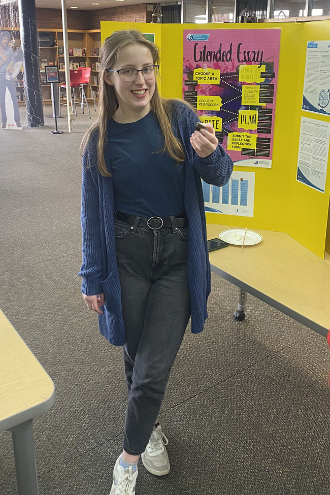 Student in front of her presentation. Student in front of her presentation.